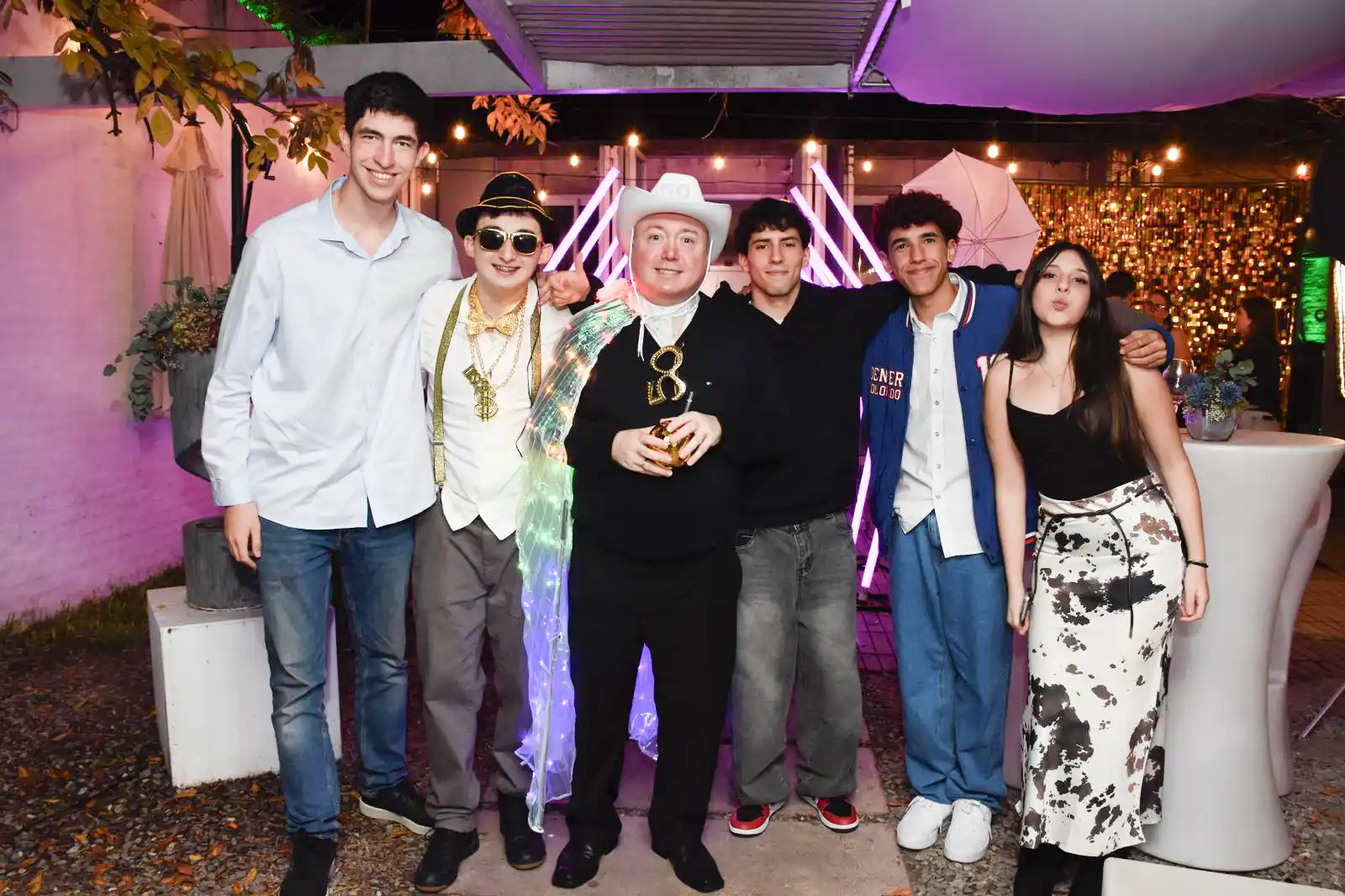 familia en cumpleaños de 50 años en Montevideo con túnel LED y fondo shimmer dorado